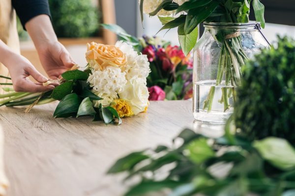 Partial view of florist making bouquet in flower shop